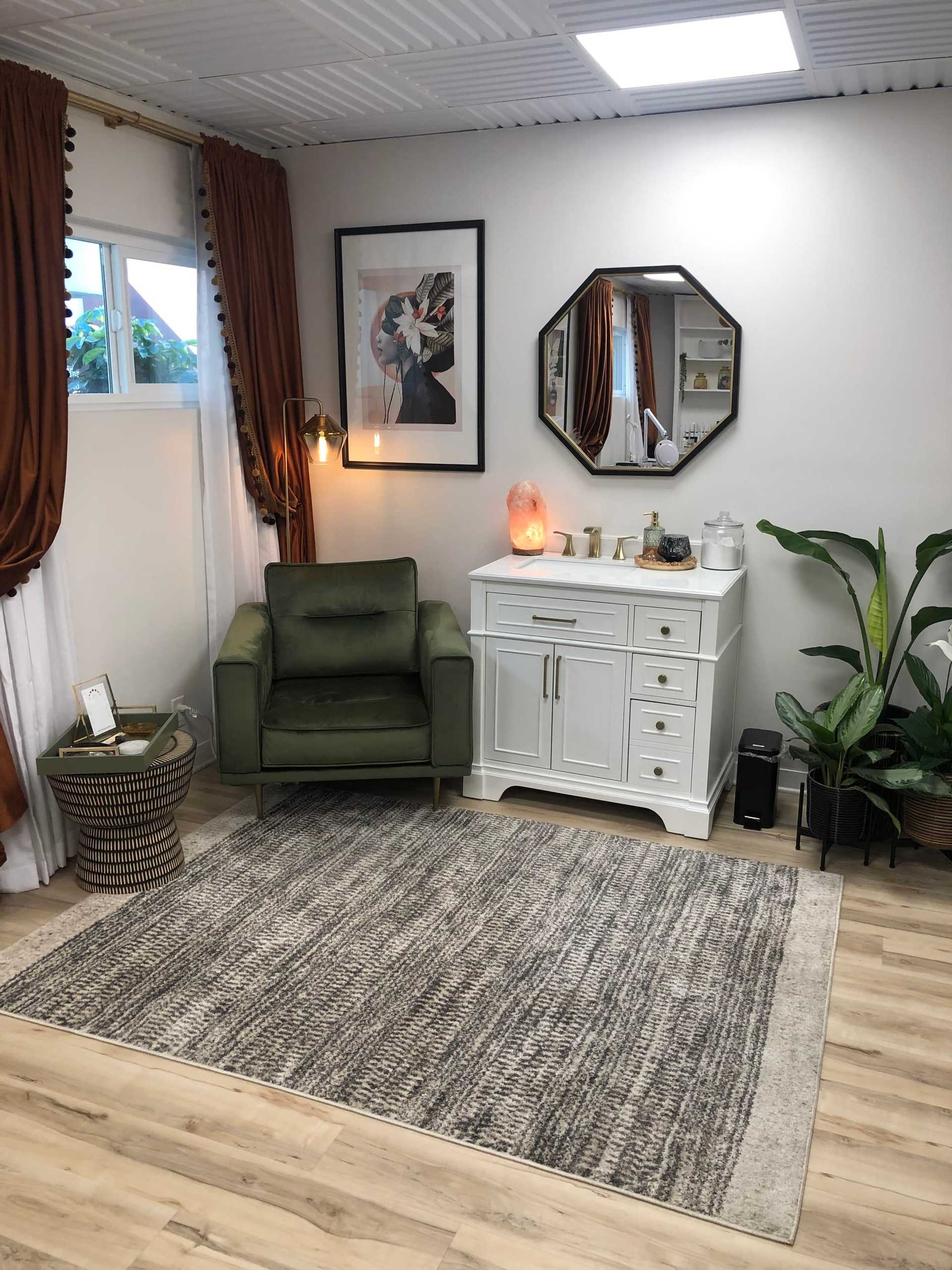 Cozy room with a green armchair, elegant rug, and stylish décor.