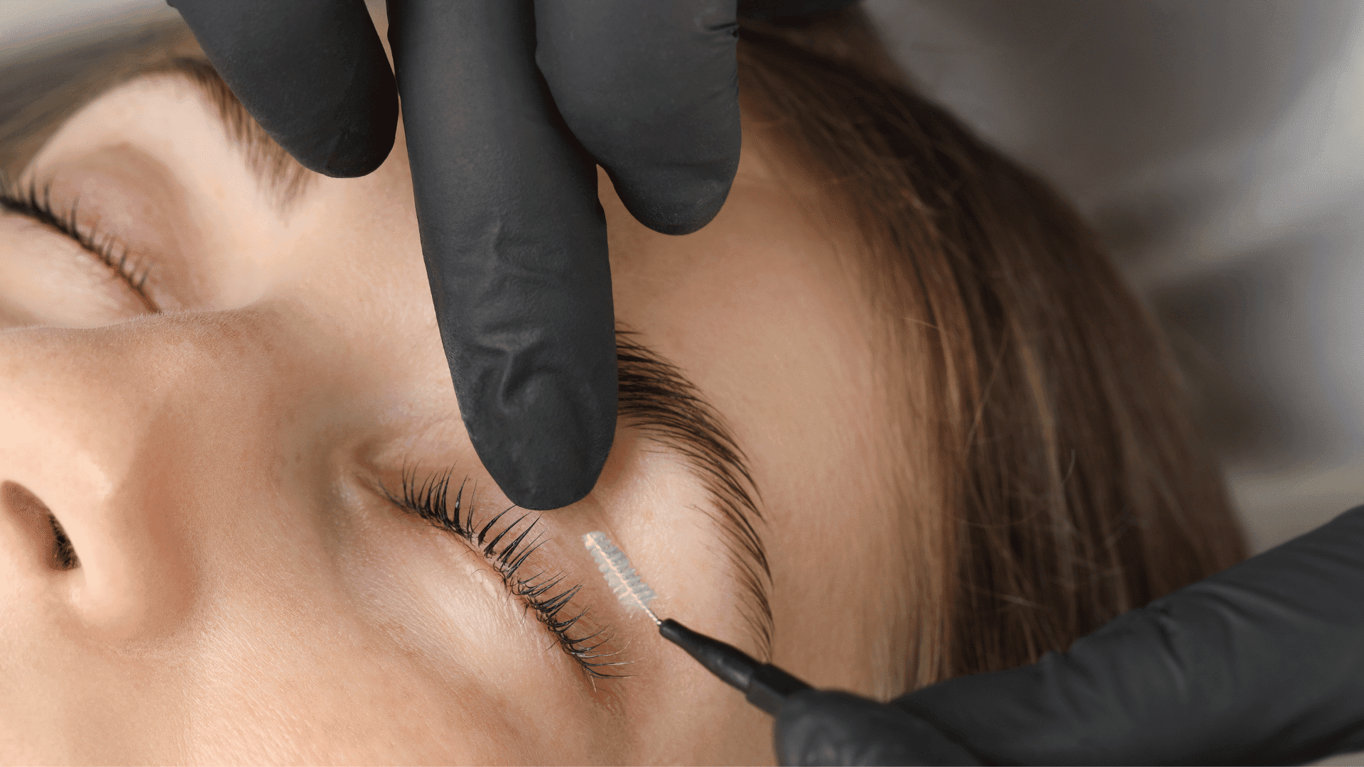 Eye care treatment applying brush to lashes with precision.